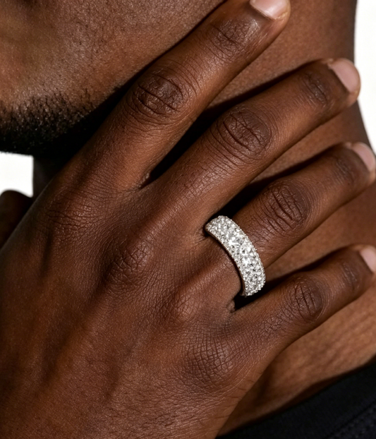 Iced band ring on hand, silver-tone with sparkling crystal-like stones.