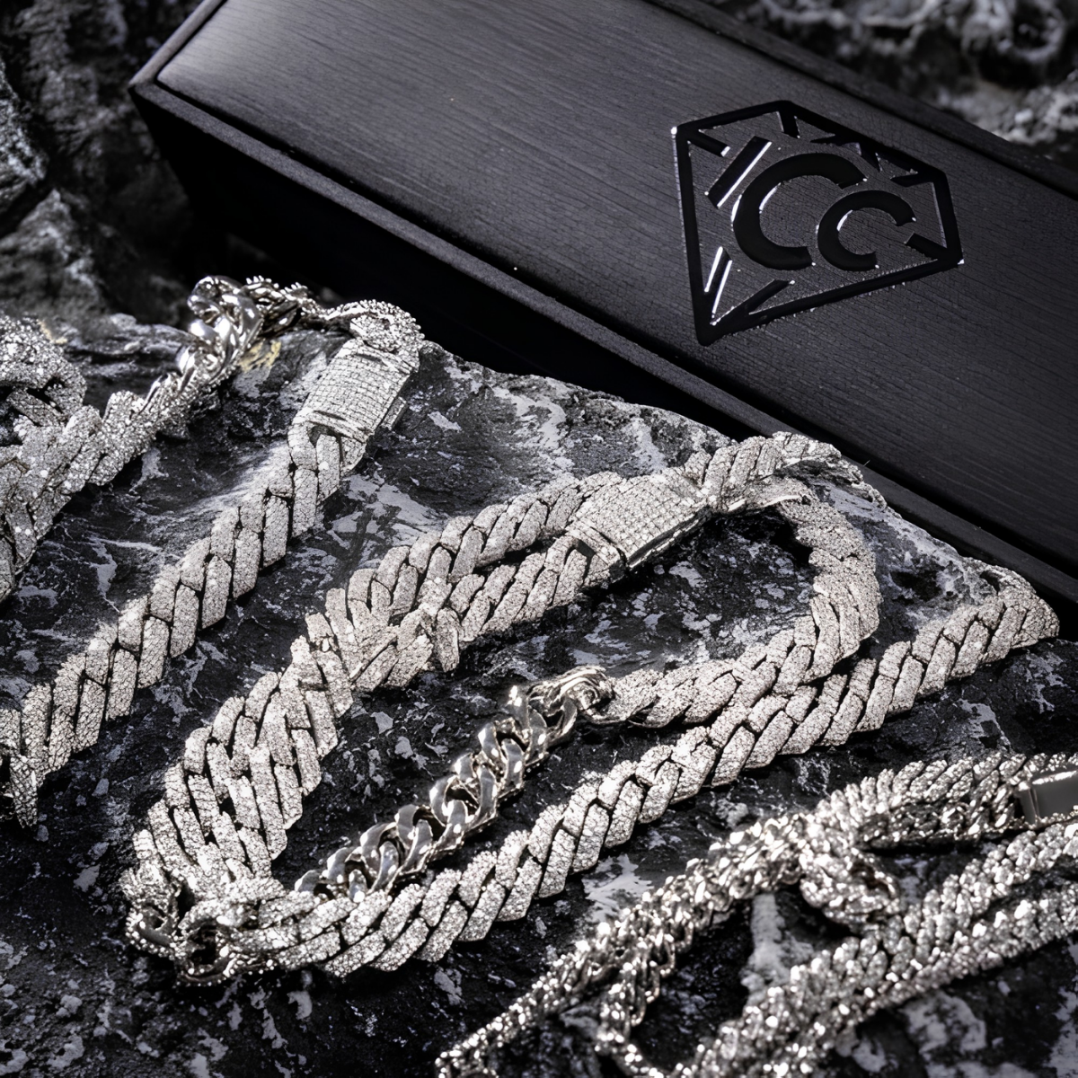 Silver-tone Cuban link chain close-up with lobster clasp and diamond-cut links on box