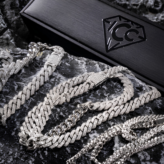 Silver-tone Cuban link chain close-up with lobster clasp and diamond-cut links on box