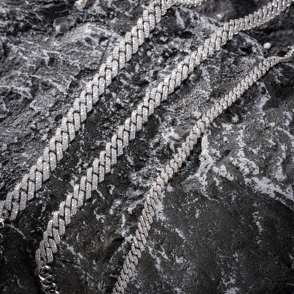 Silver Cuban link chain with micro pavé stones, close-up on layered links